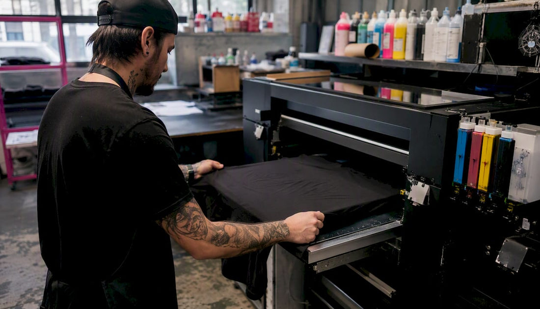Hands spraying ink with DTG printer on t-shirt