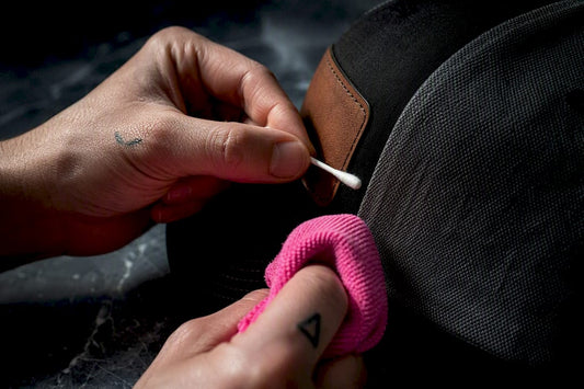 Hands gently cleaning a leather hat patch