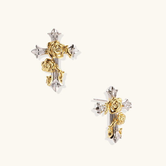 Gold-plated cross earrings with dimensional roses and crystal details on cream background, 18k gold over brass construction.