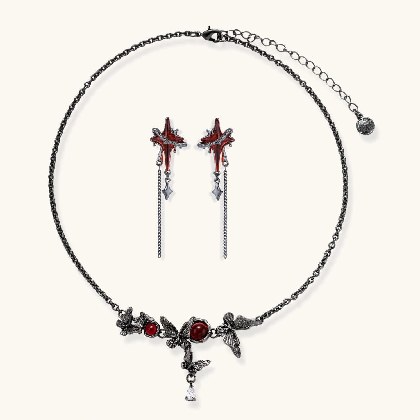 Gothic jewelry set with red resin cross pendants wrapped in dark metal chains on cream background.