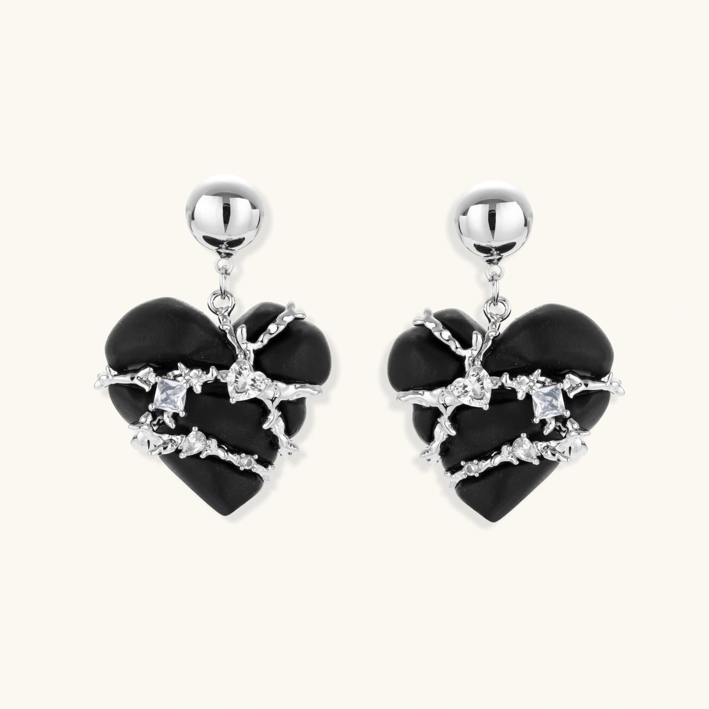 Black heart-shaped wood earrings with decorative silver chains and crystal accents hanging from silver ball studs